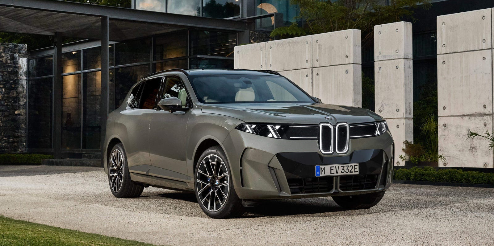 Official BMW image of the 2027 BMW iX5 electric SUV parked in front of a modern building.