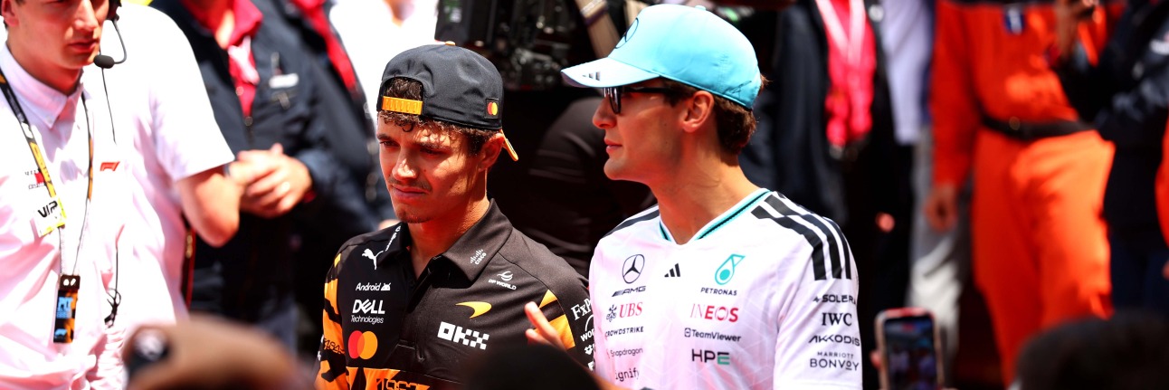 Lando Norris and George Russell walking through the Formula 1 paddock.