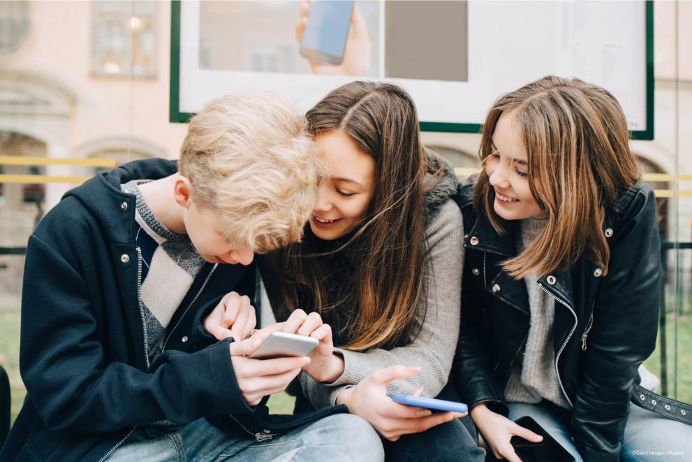 European Commission-hosted image of teenagers looking at a smartphone.