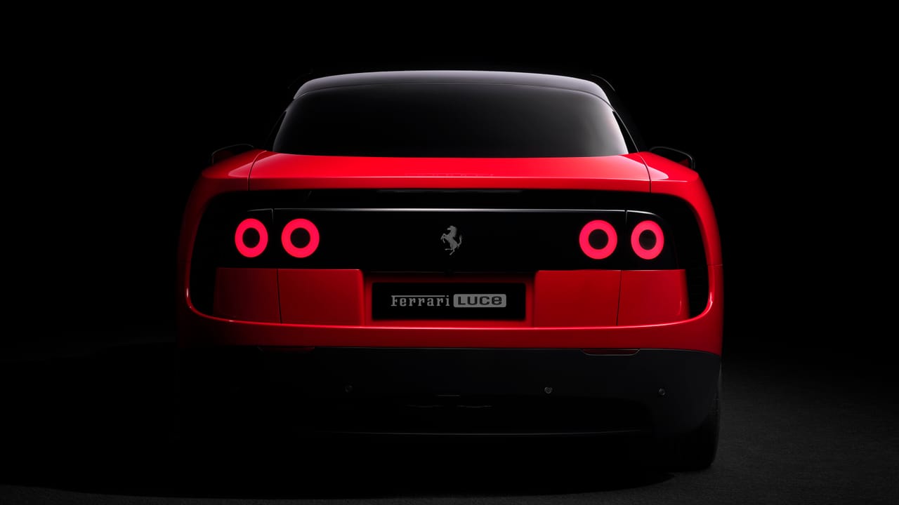 Rear view of the Ferrari Luce EV with circular tail lights in a dark studio.