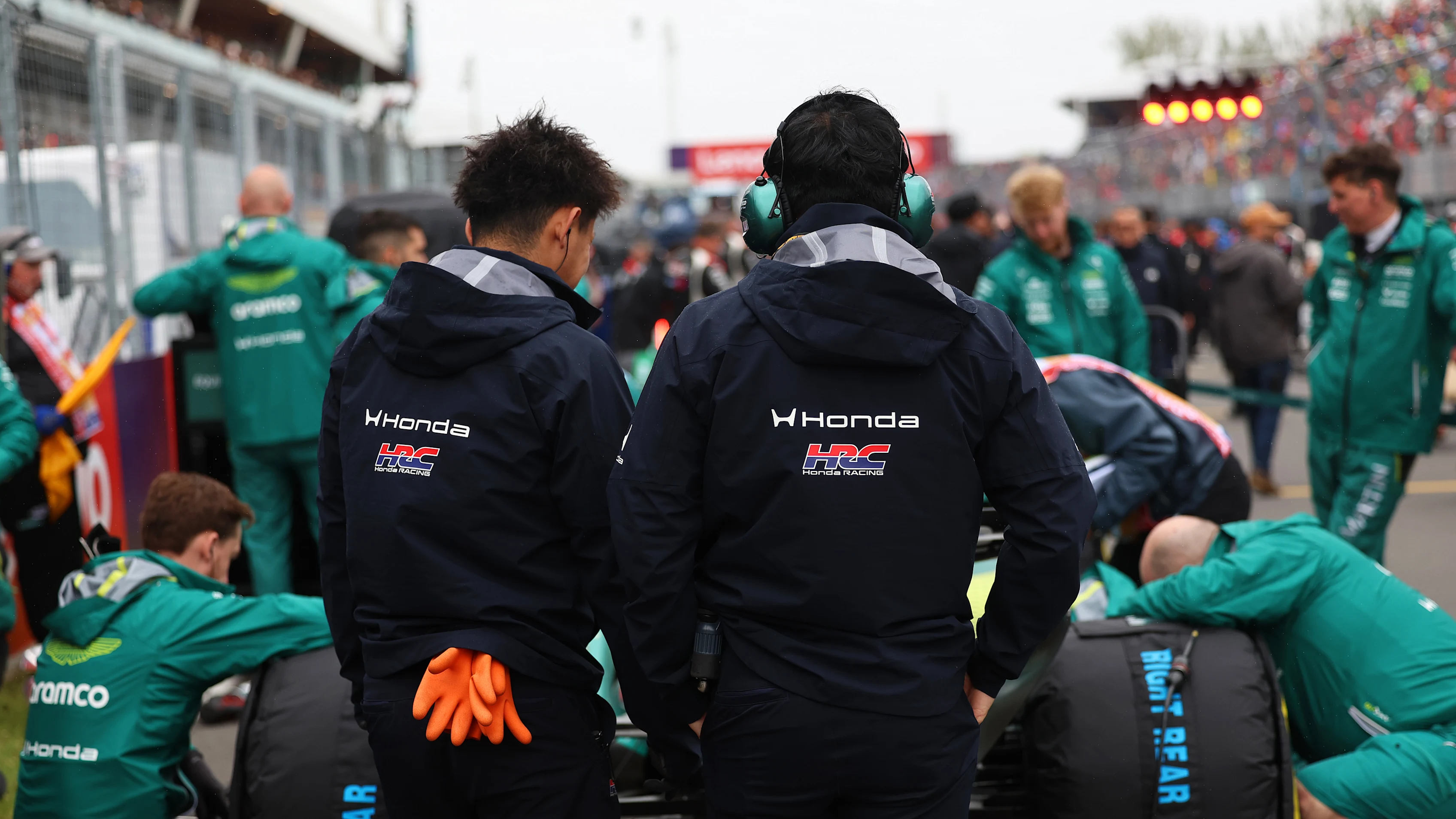 Honda Racing staff working with the Aston Martin Formula 1 team on the grid.