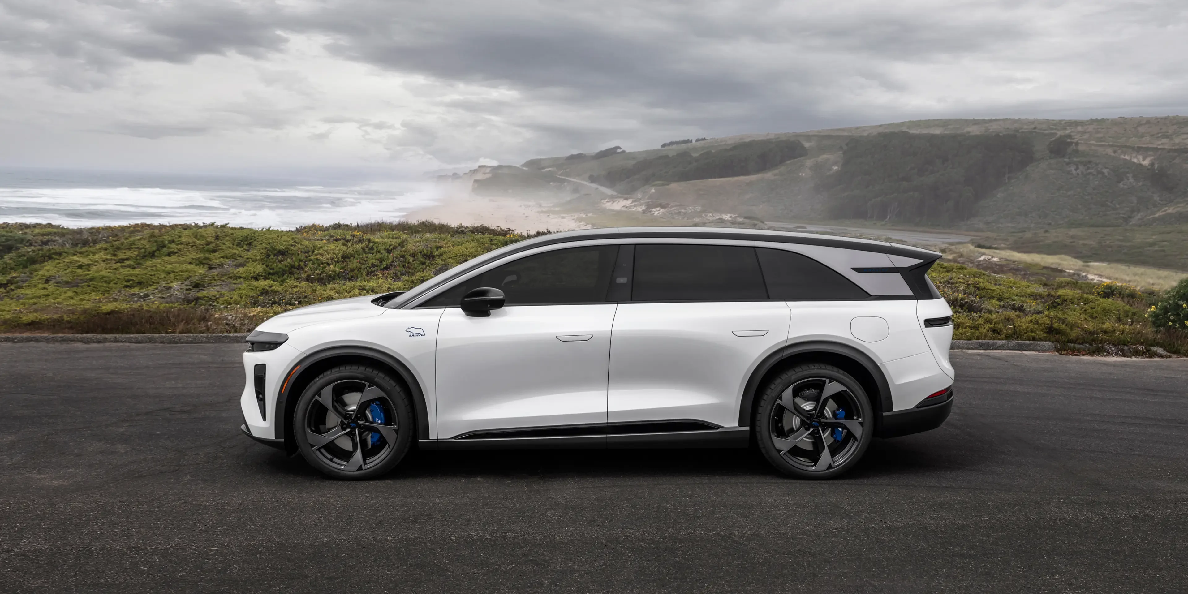 Official Lucid image of the Gravity GT-S parked beside a coastal road.