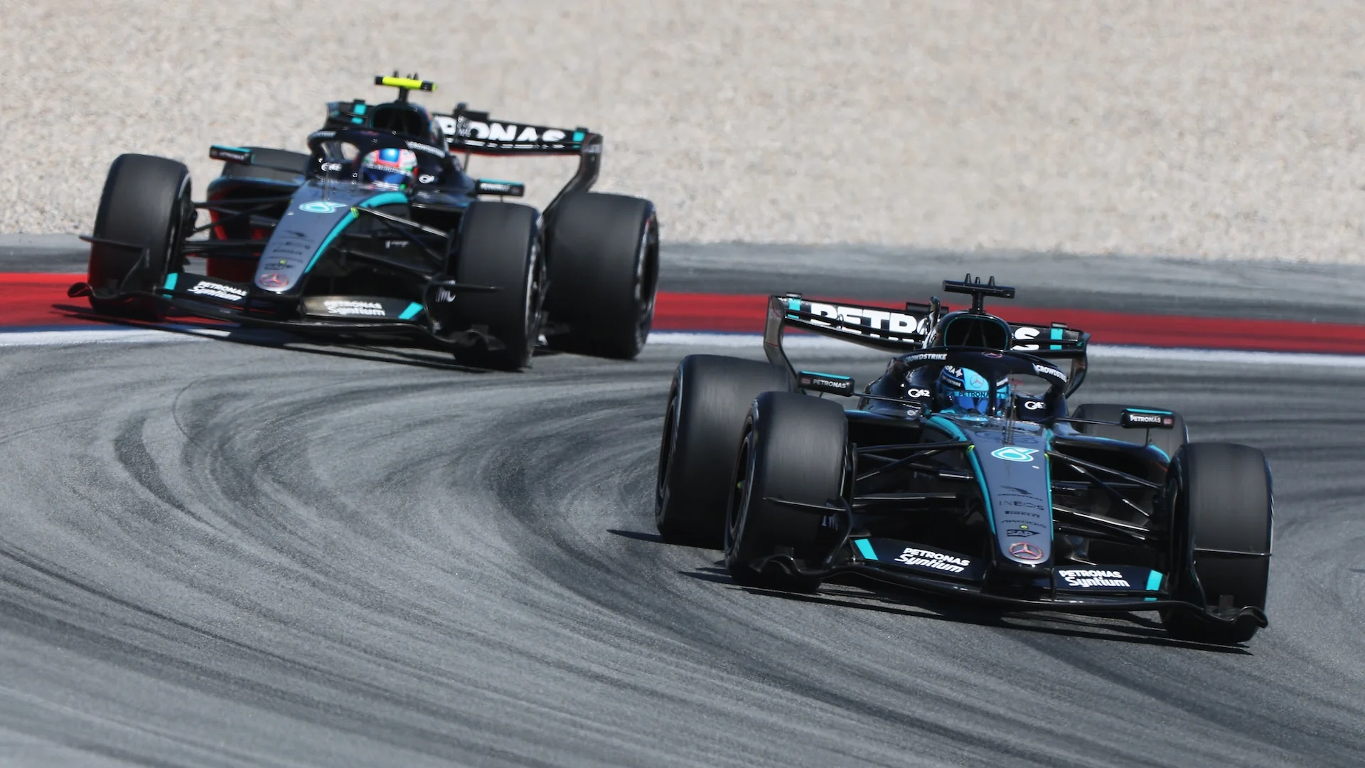 Two Mercedes Formula 1 cars running through a corner during the 2026 Barcelona-Catalunya Grand Prix.