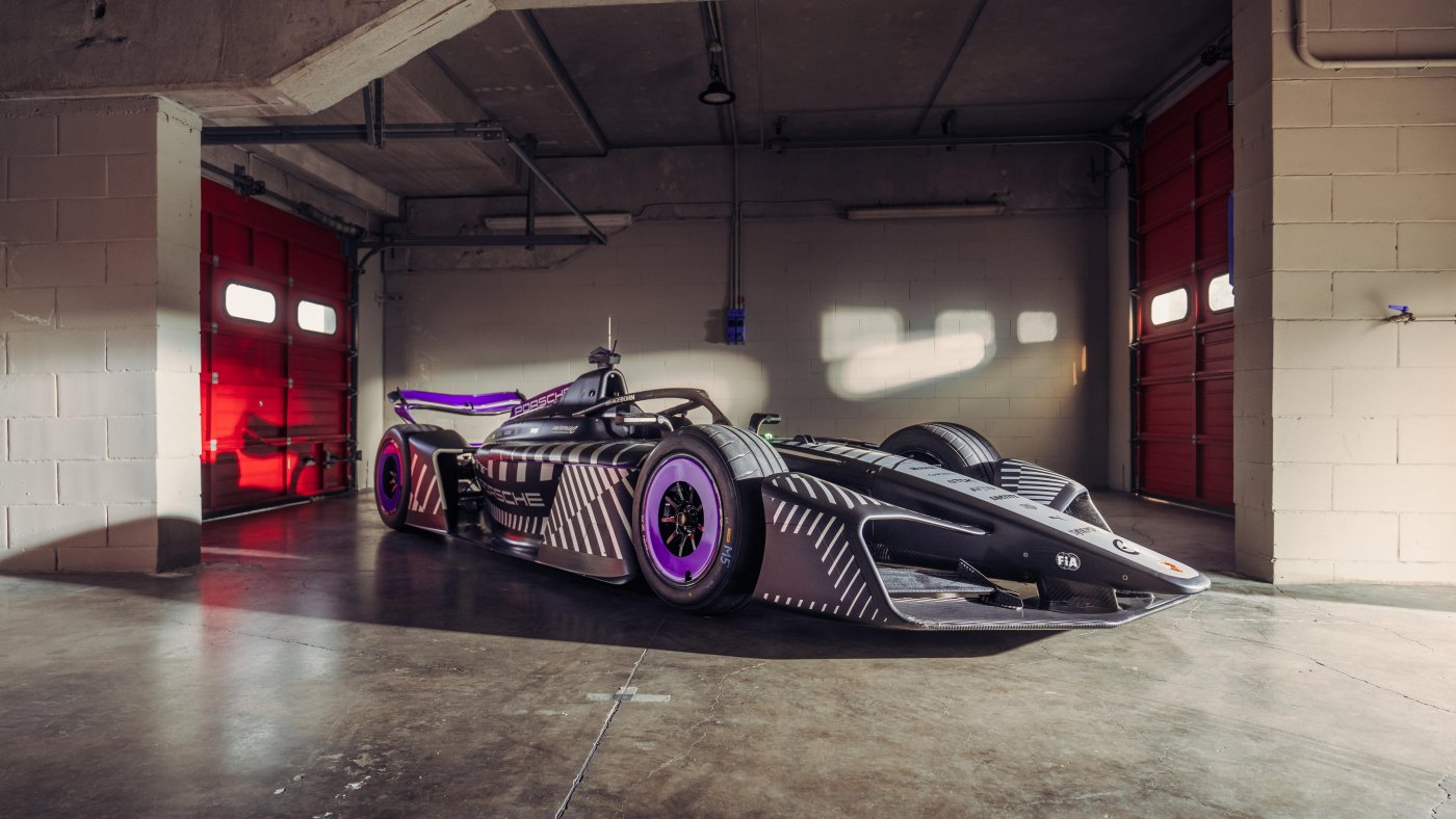 Porsche’s 975 RSE GEN4 Formula E car in a garage, photographed from the front three-quarter angle.