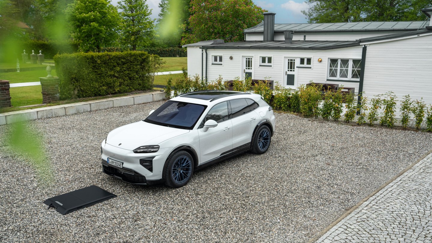 A Porsche Cayenne Turbo Electric positioned over Porsche Wireless Charging equipment in Munich.